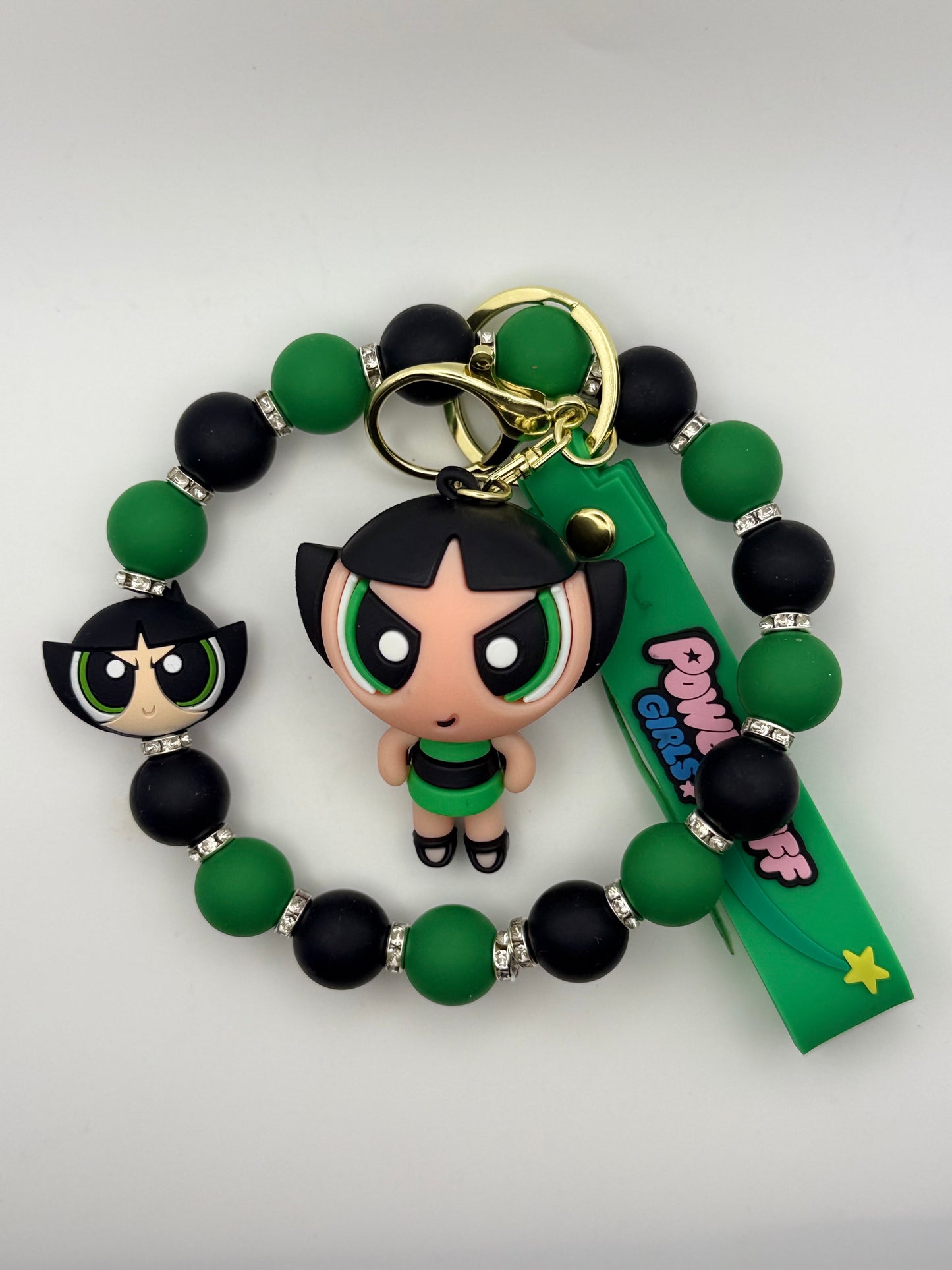 Green and black beaded bracelet with a character charm on a white background