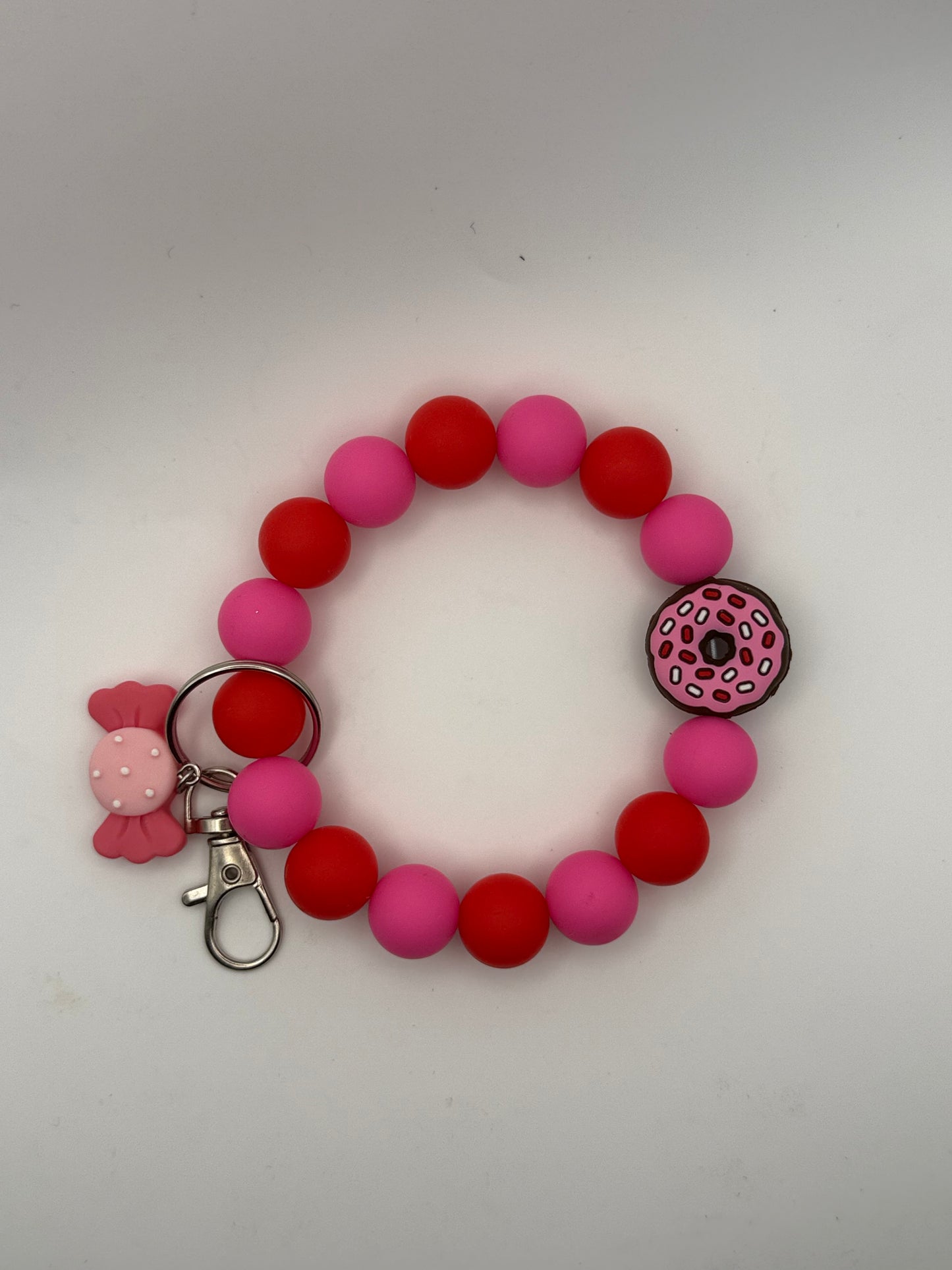 Colorful beaded bracelet keychain with a donut charm on a white background