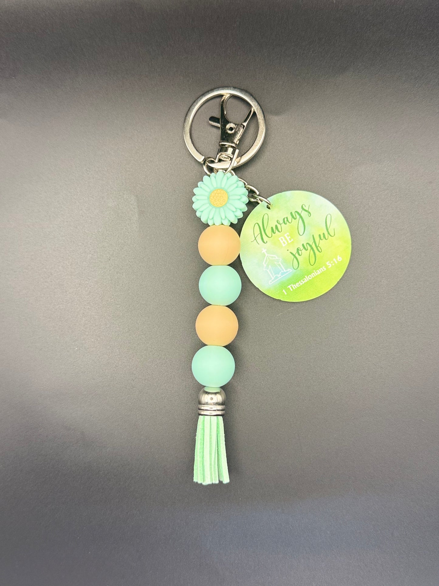 Flower Keychain with beads and tassel on a gray background