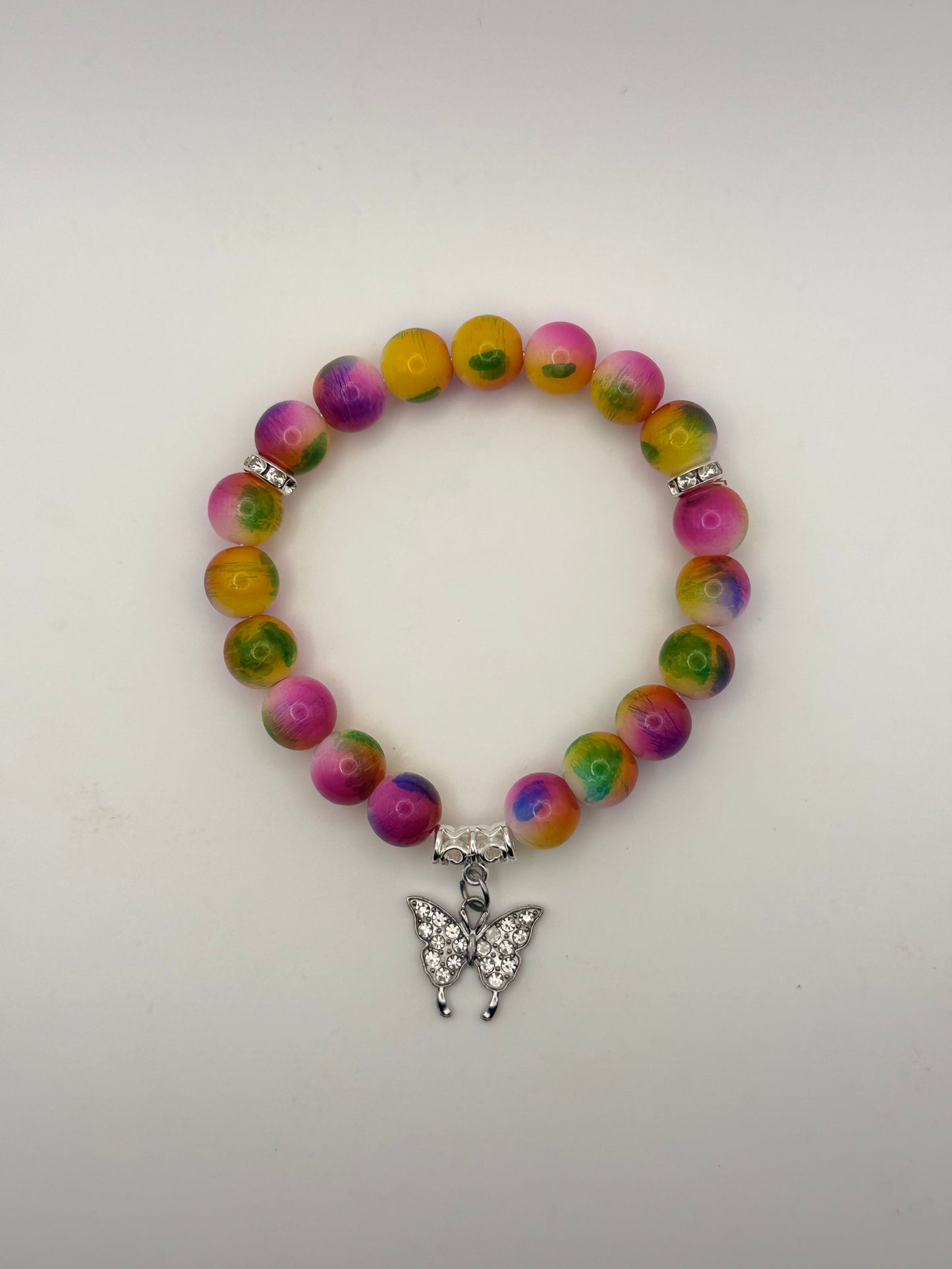 Multicolored beaded bracelet with a silver butterfly charm on a white background
