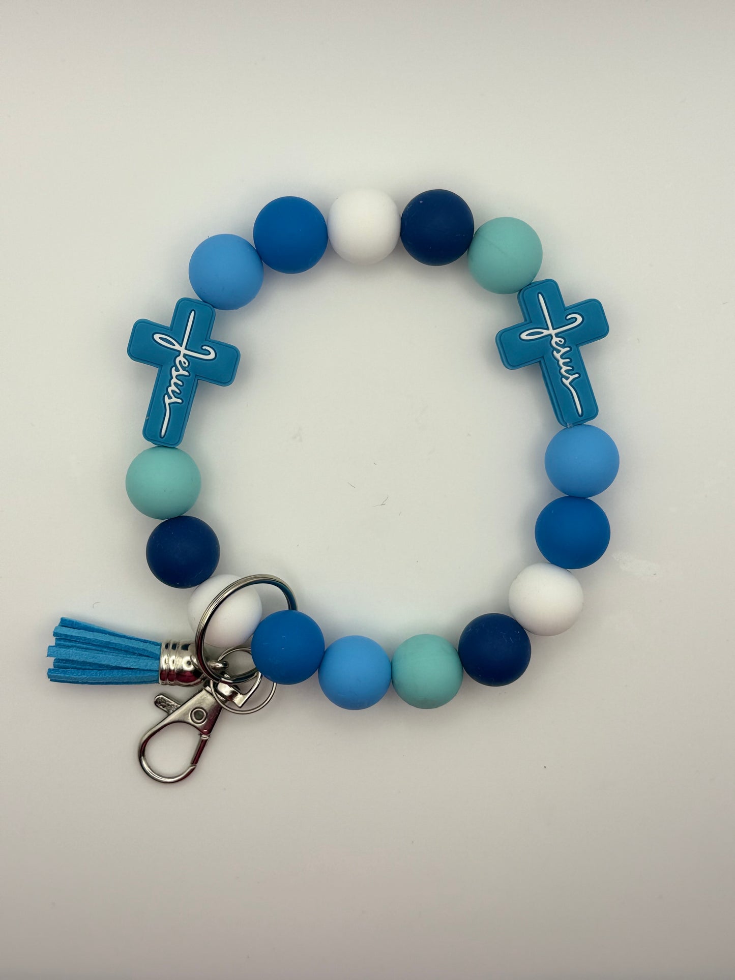Colorful beaded bracelet with cross charms and a tassel on a white background