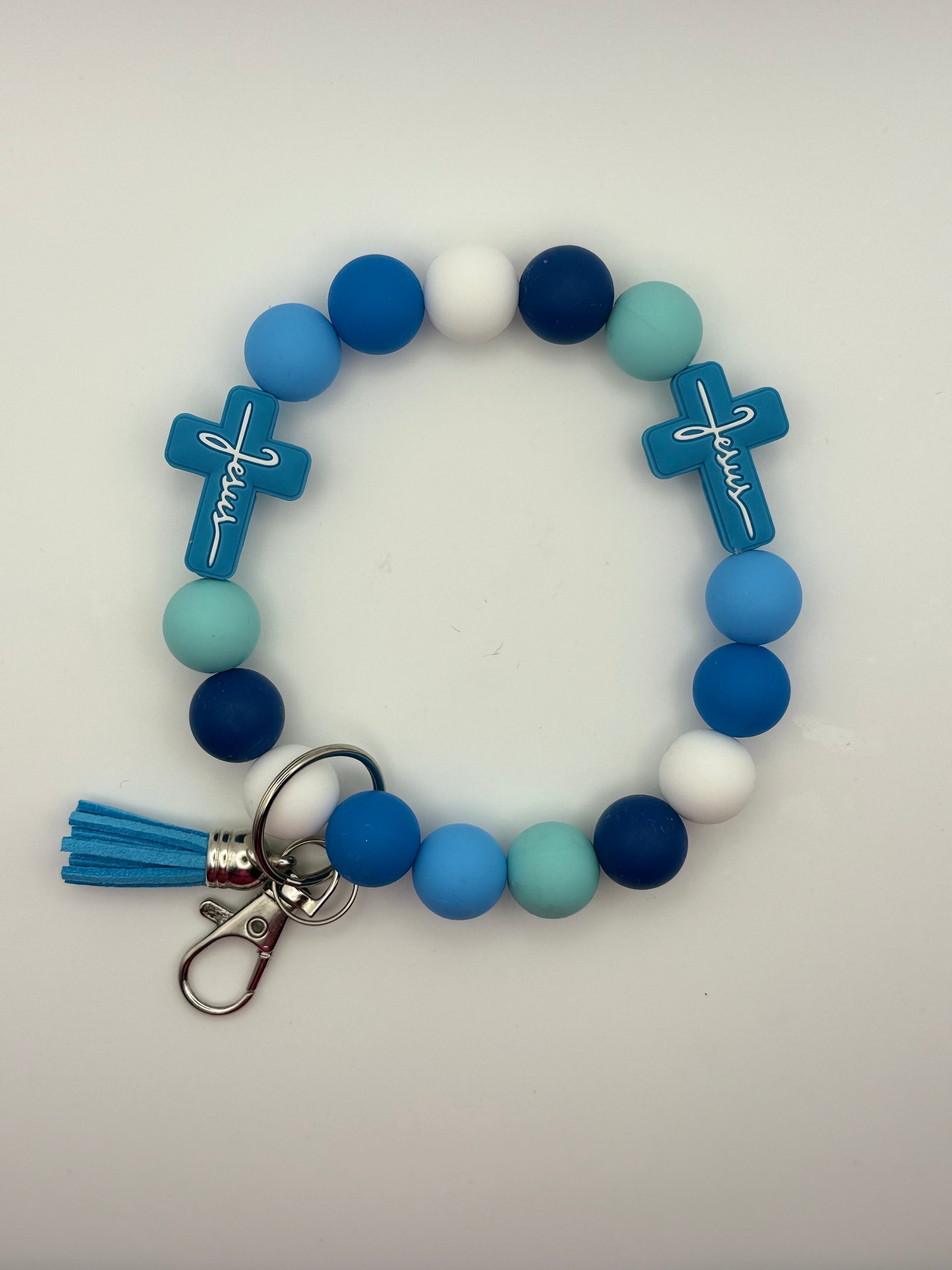 Colorful beaded bracelet with cross charms and a tassel on a white background