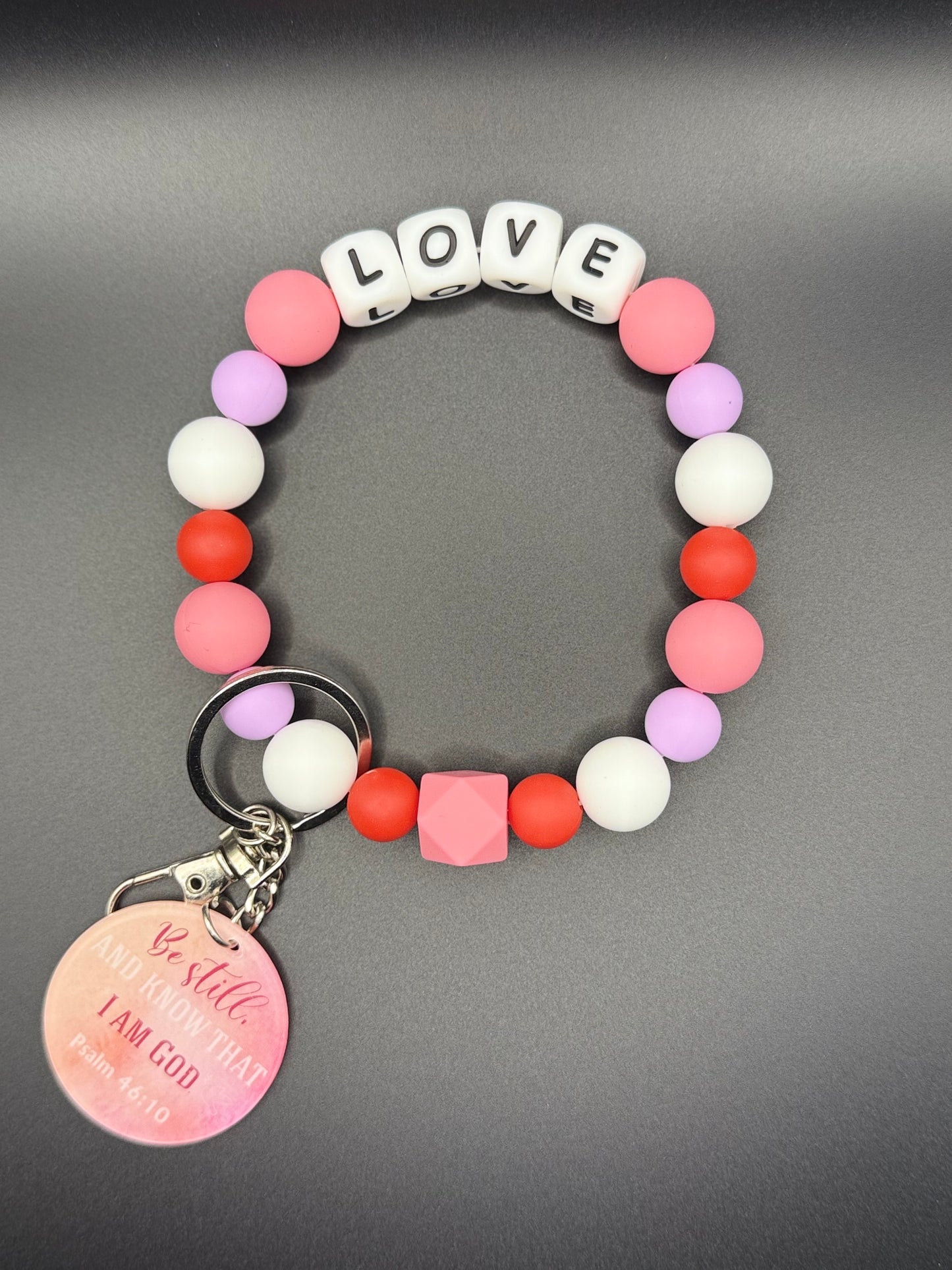 Colorful beaded bracelet with 'LOVE' charm on a gray background