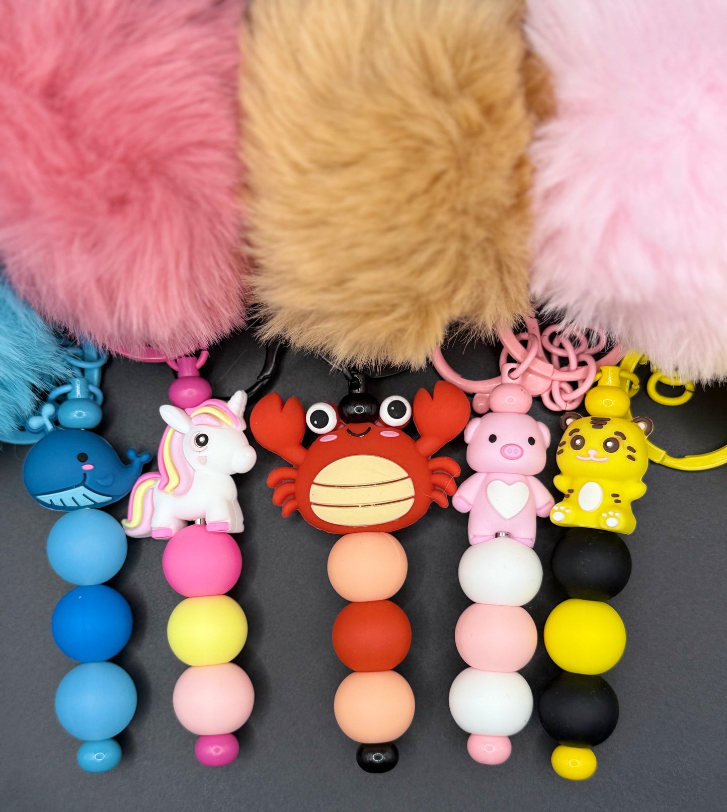 Colorful keychains with various designs on a gray background