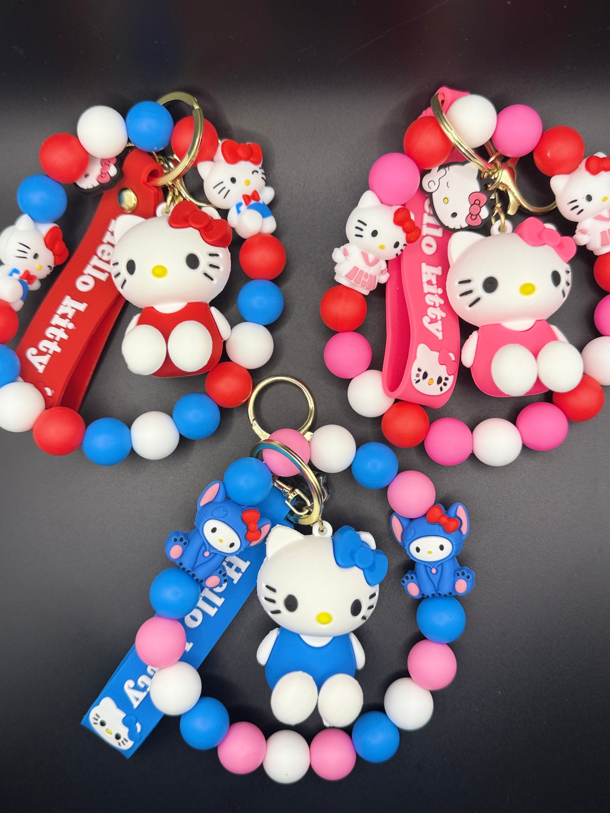 Colorful keychains with Kitty characters on a black background