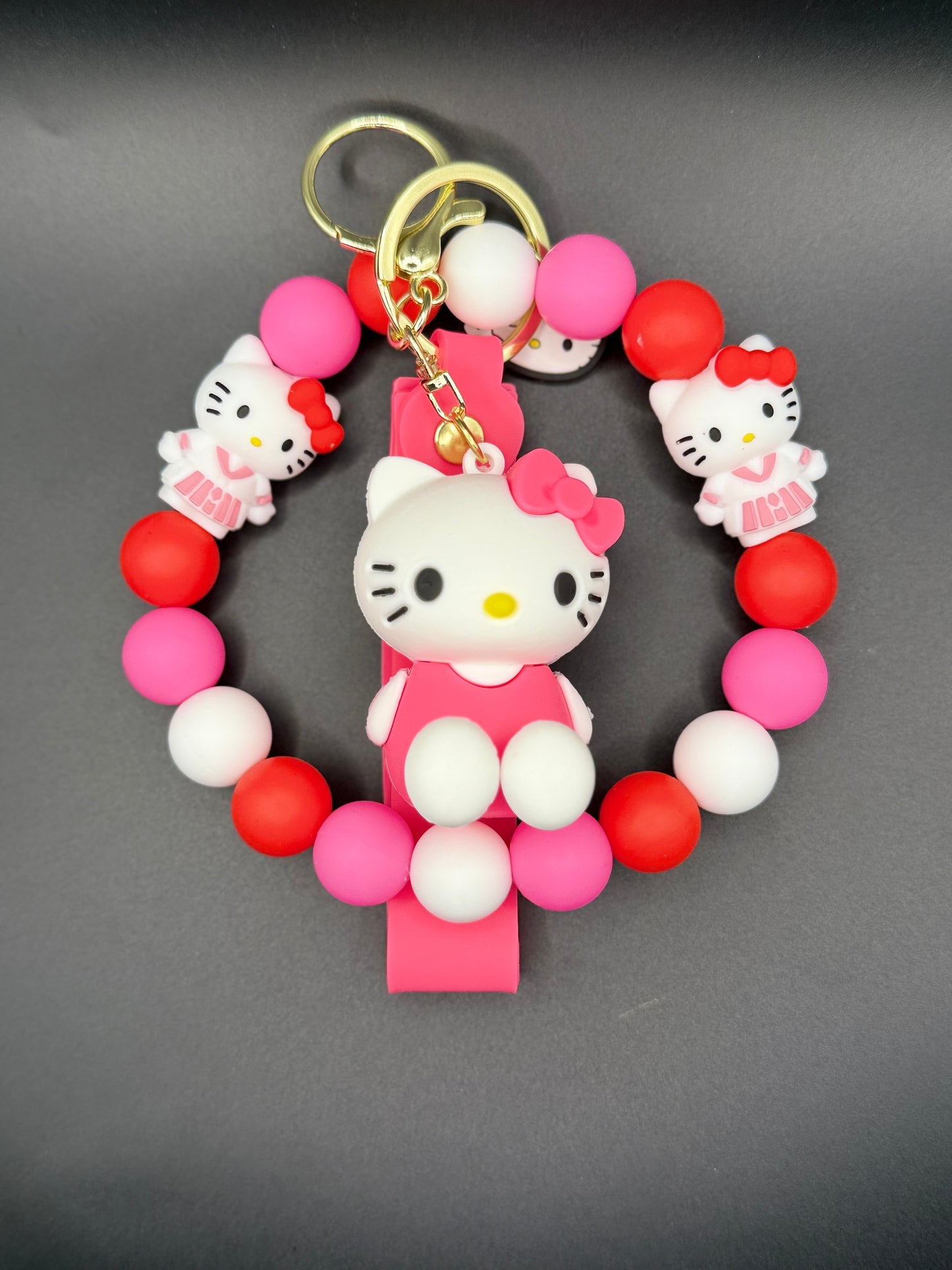 Keychain with Kitty figure and colorful beads on a gray background