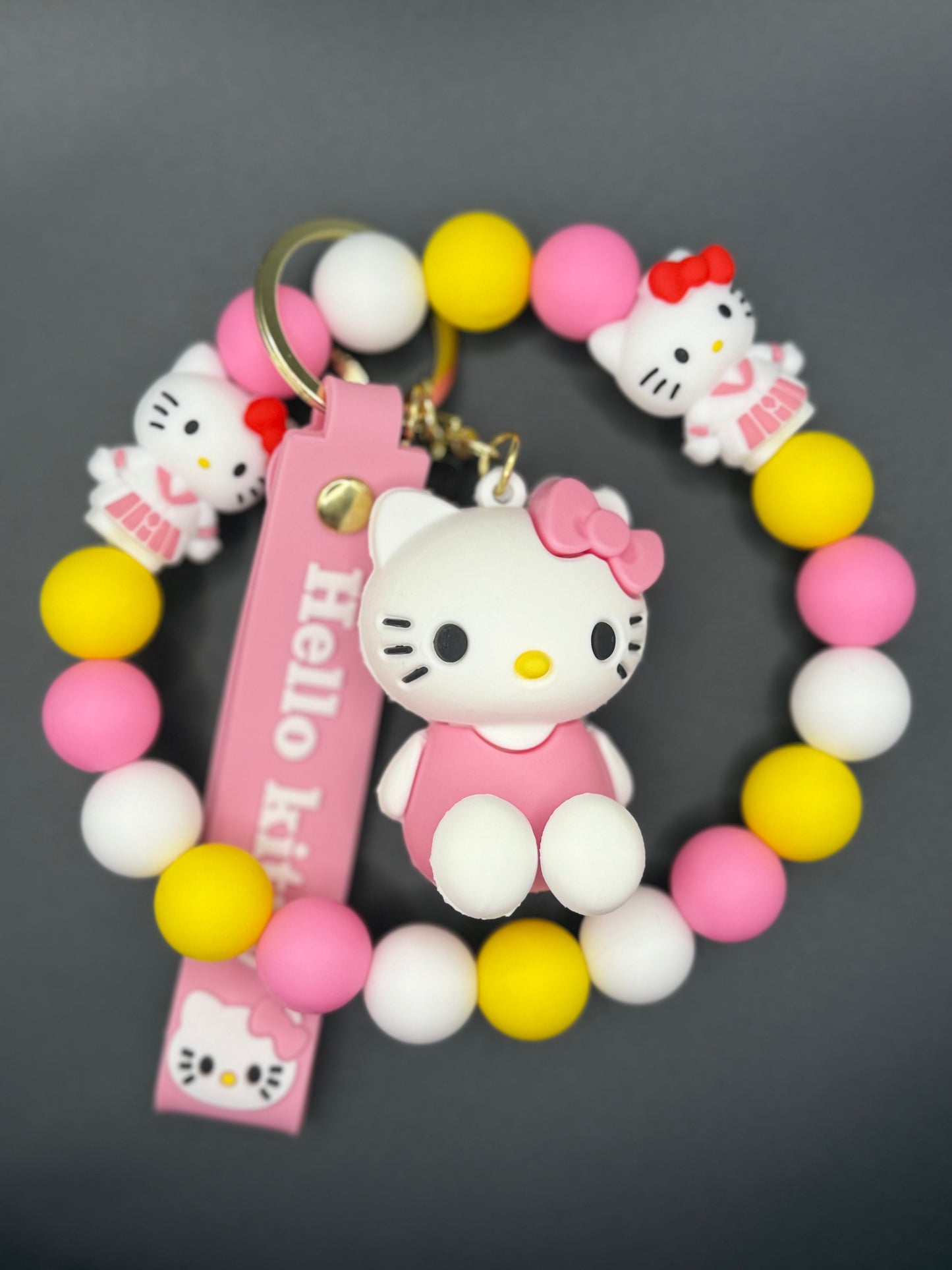 Colorful bracelet with Kitty charm on a dark background