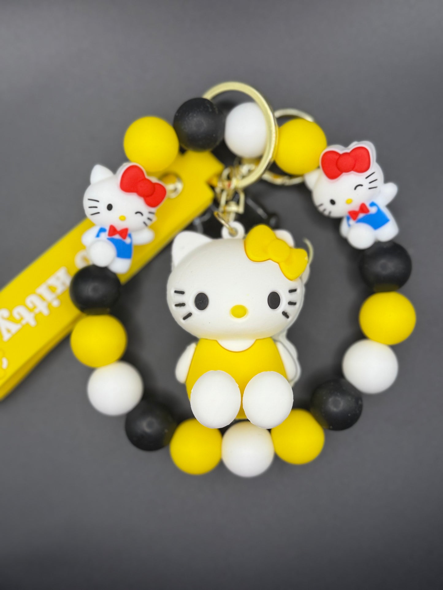 Keychain with Kitty character and colorful beads on a dark background