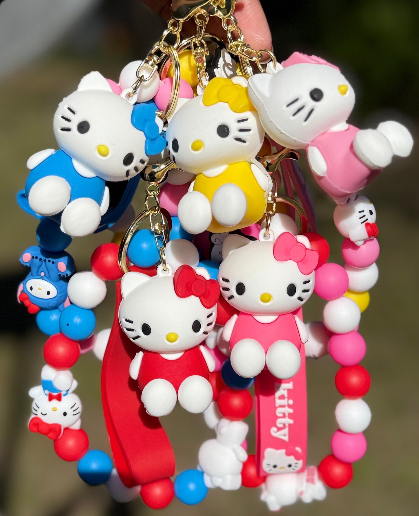 Colorful keychain Kitty figures and beads on a blurred background
