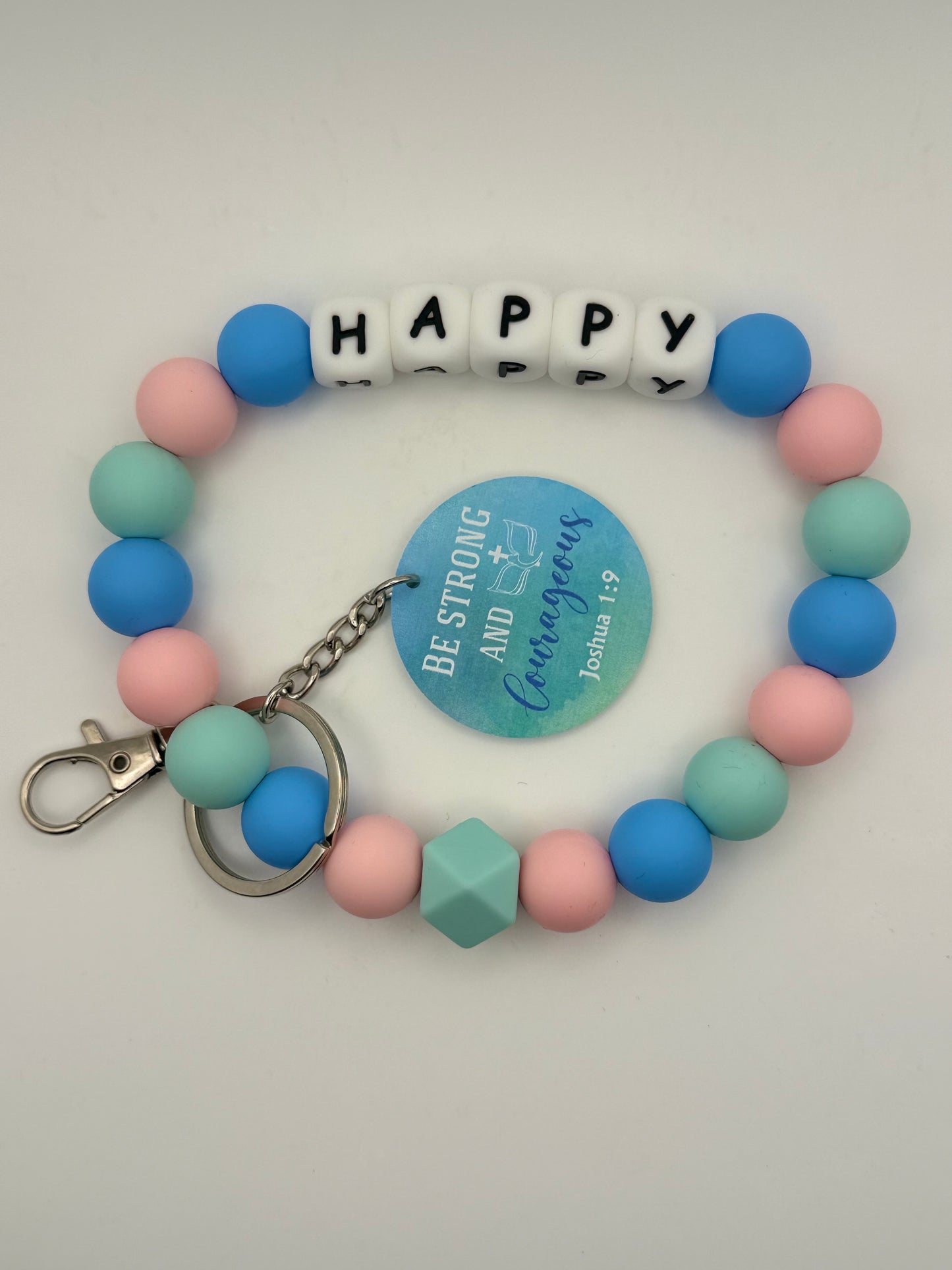 Colorful beaded bracelet with letter beads spelling 'HAPPY' on a gray background