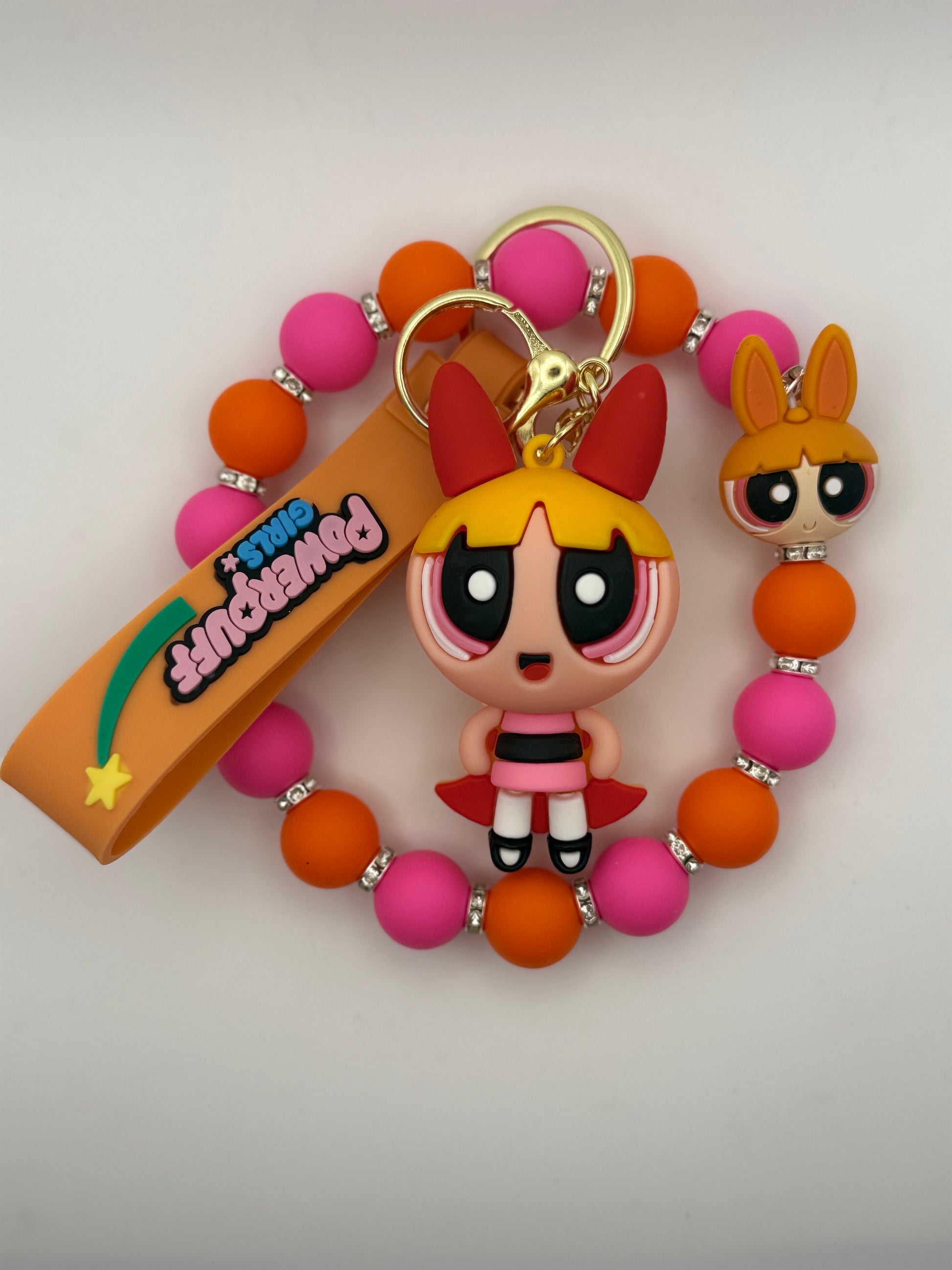 Keychain with cartoon character and colorful beads on a plain background