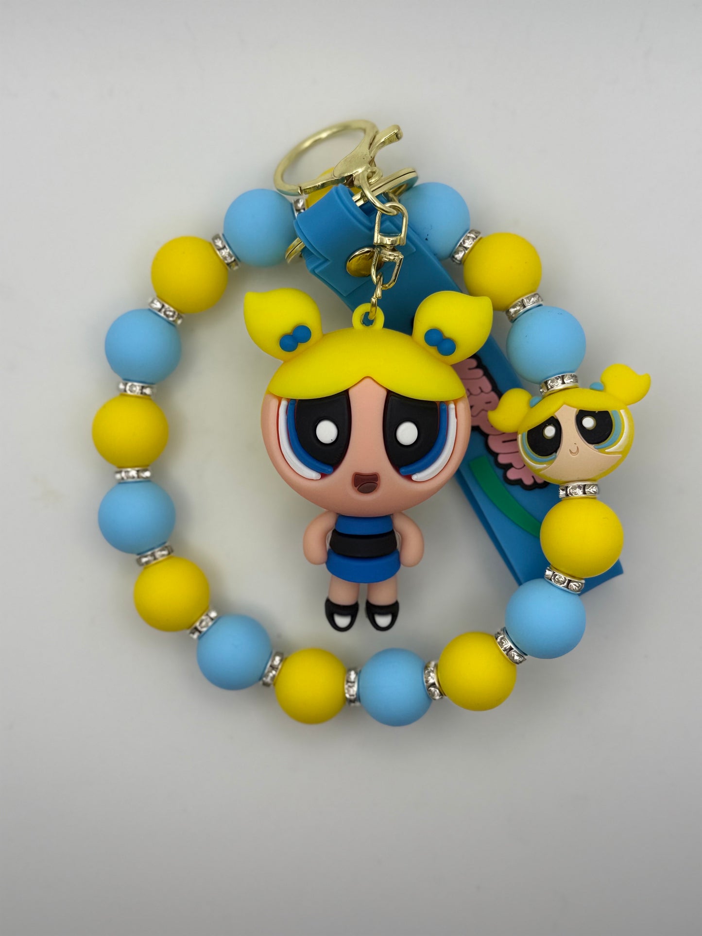 Bracelet with cartoon character charm and blue and yellow beads on a light gray background