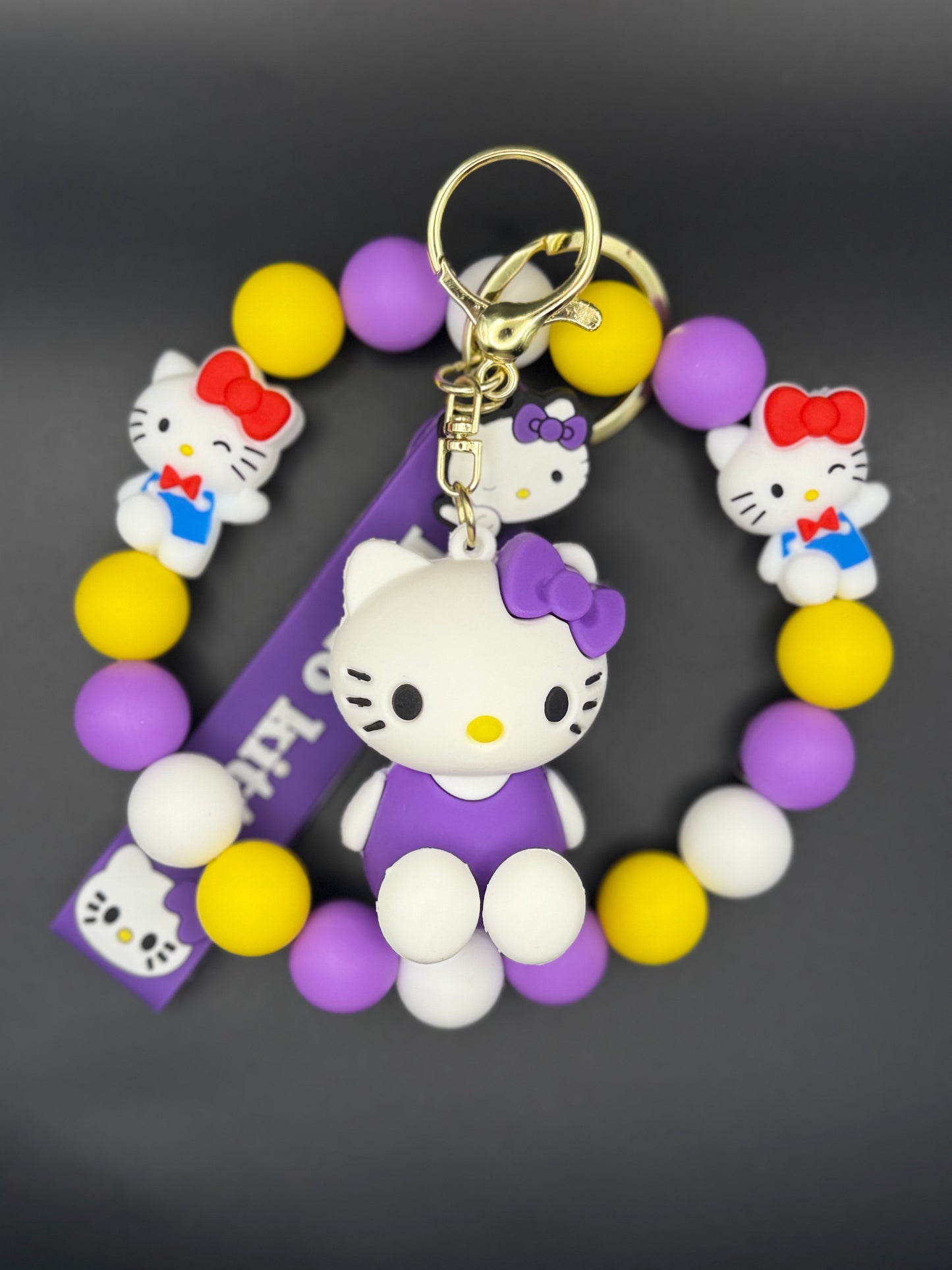 Colorful keychain with Kitty figure and ball charms on a dark background