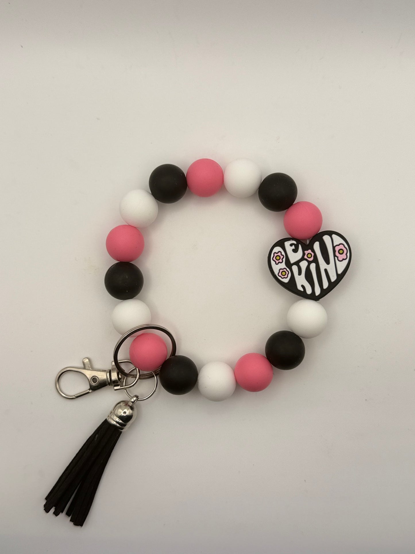 Beaded keychain with heart-shaped charm and tassel on a light gray background