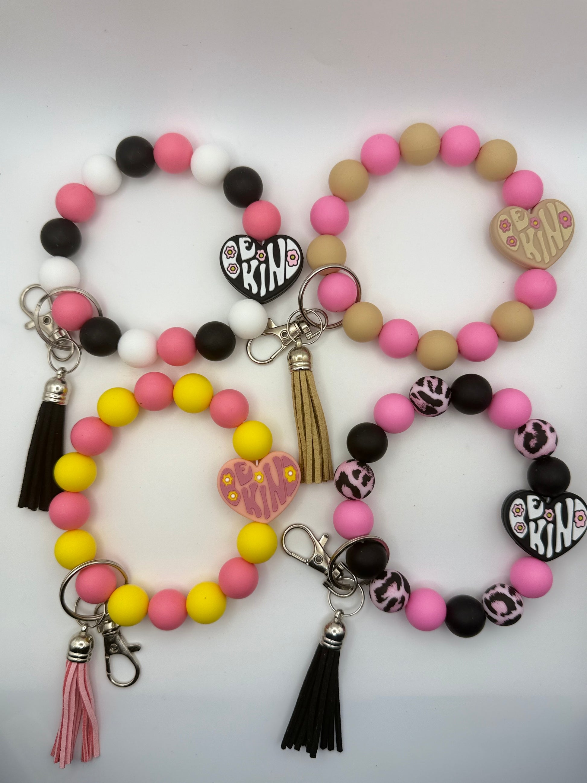 Set of colorful beaded keychains and bracelets with tassels on a white background