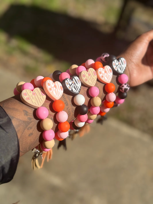 Colorful beaded bracelet keychains on a wrist with a blurred natural background