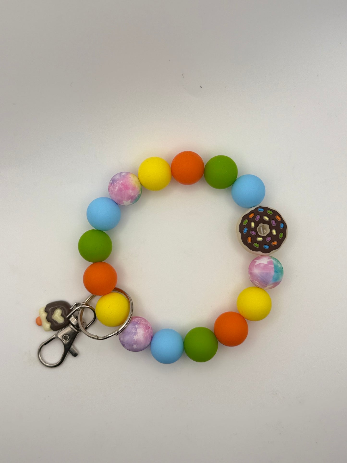 Colorful beaded bracelet keychain with a donut charm on a white background