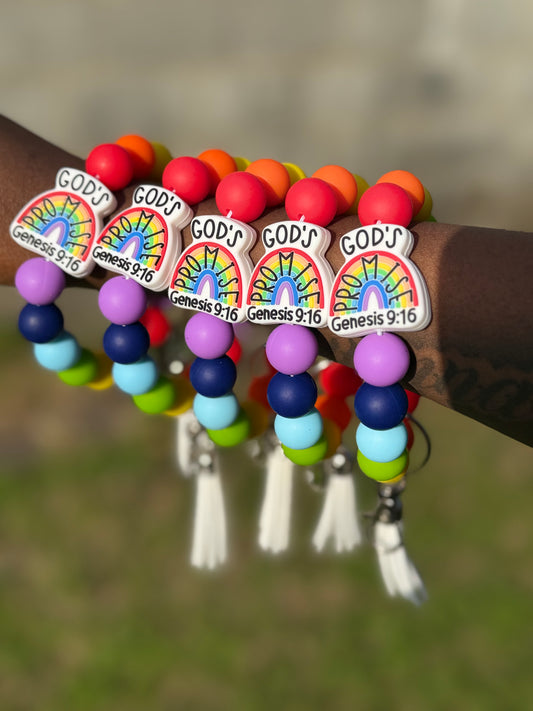 Colorful beaded bracelet with 'GOD'S PROMISE' charms on a blurred natural background