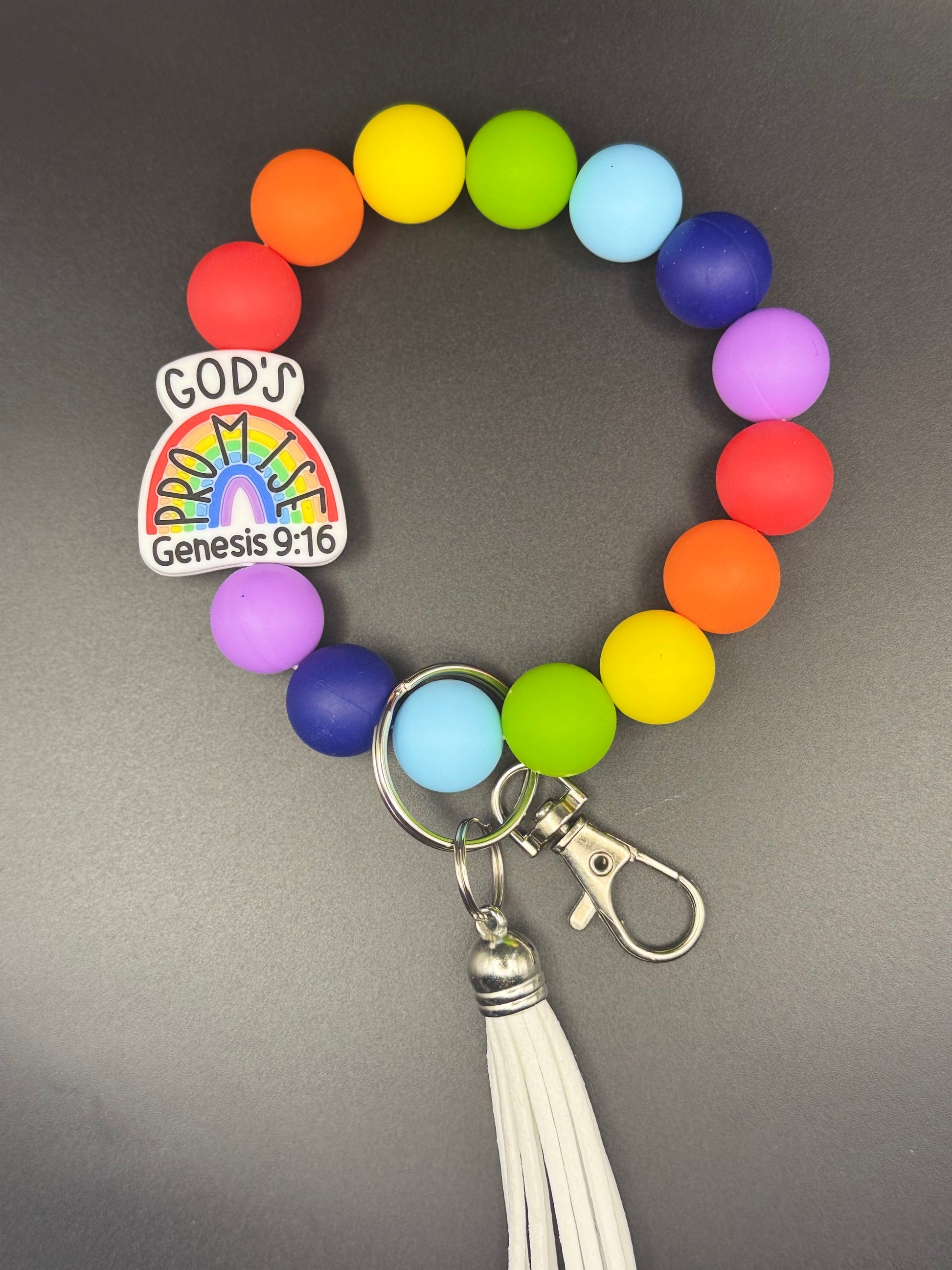 Colorful beaded keychain with a rainbow design and 'God's Genesis 9:16' tag on a gray background
