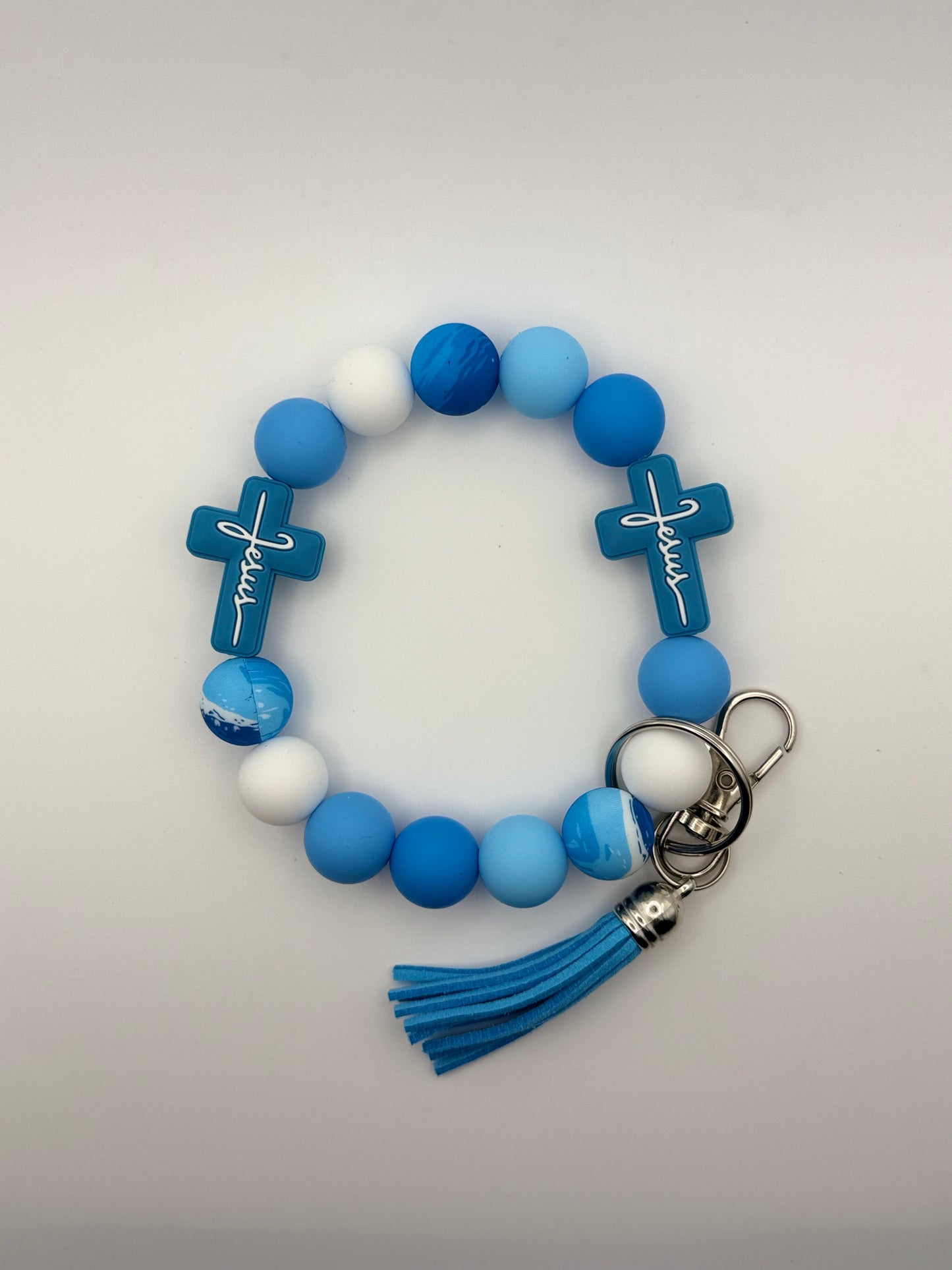 Blue and white beaded keychain with cross charms on a light gray background