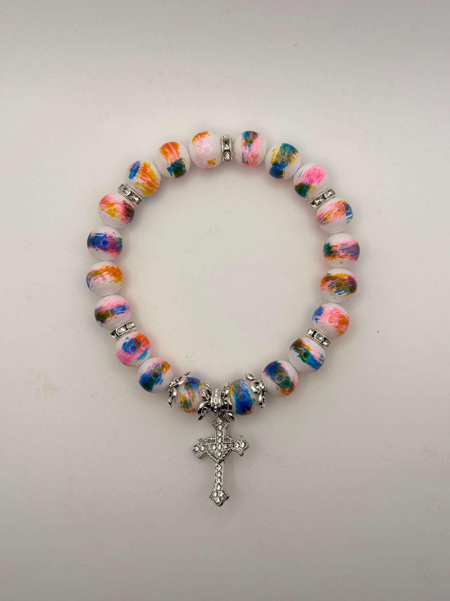 Multicolored beaded bracelet with a silver cross charm on a white background