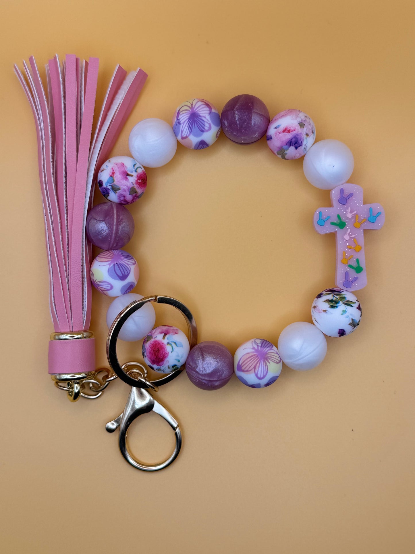 Beaded keychain with floral designs on a beige background