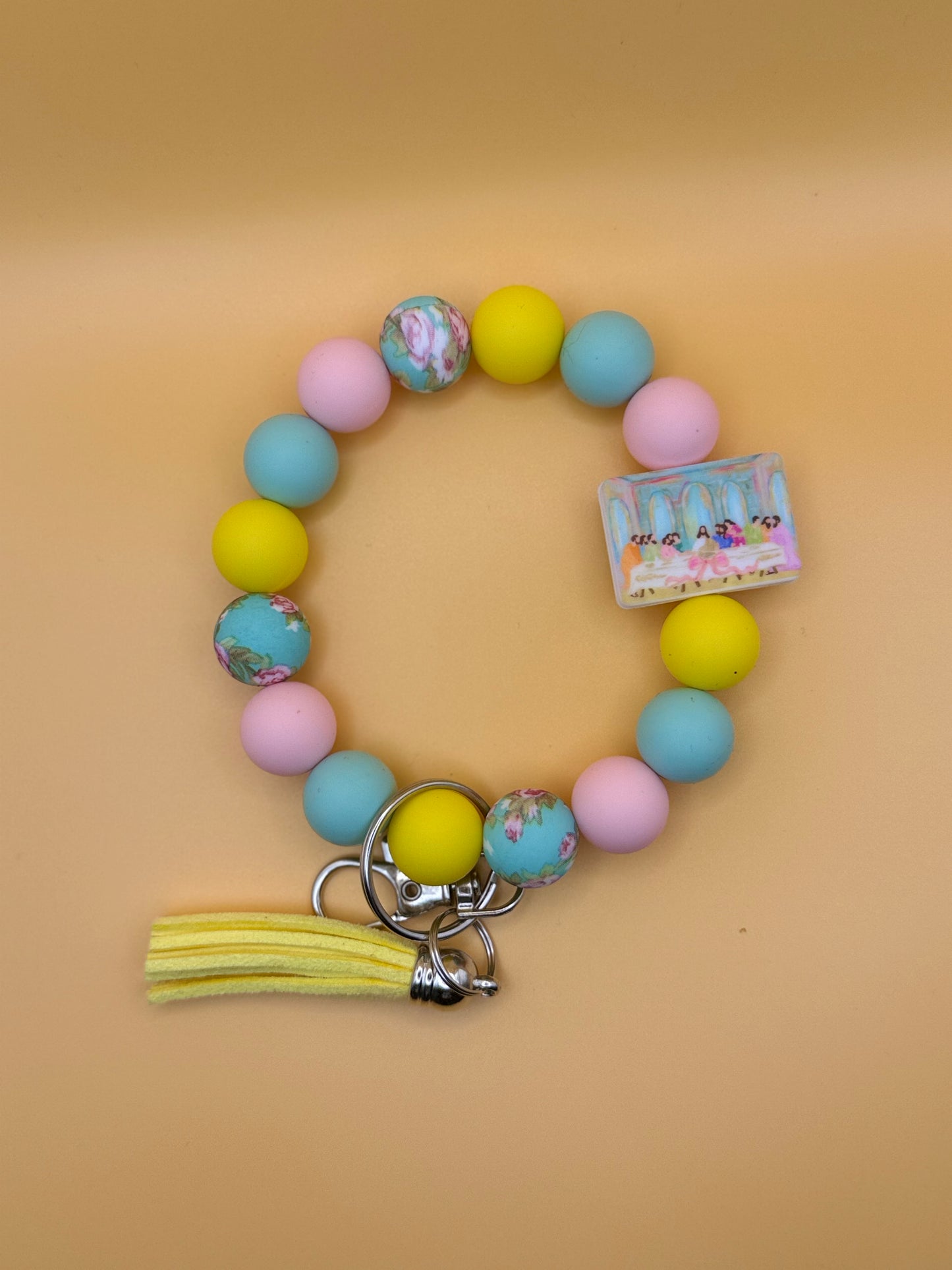Colorful beaded keychain with a tassel on a beige background