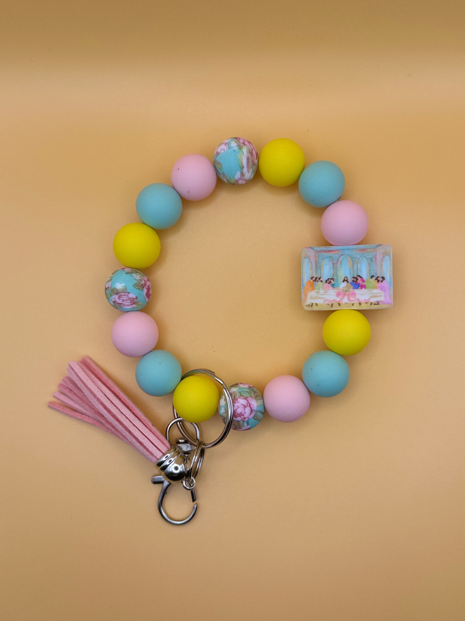 Colorful beaded keychain with tassel on a beige background