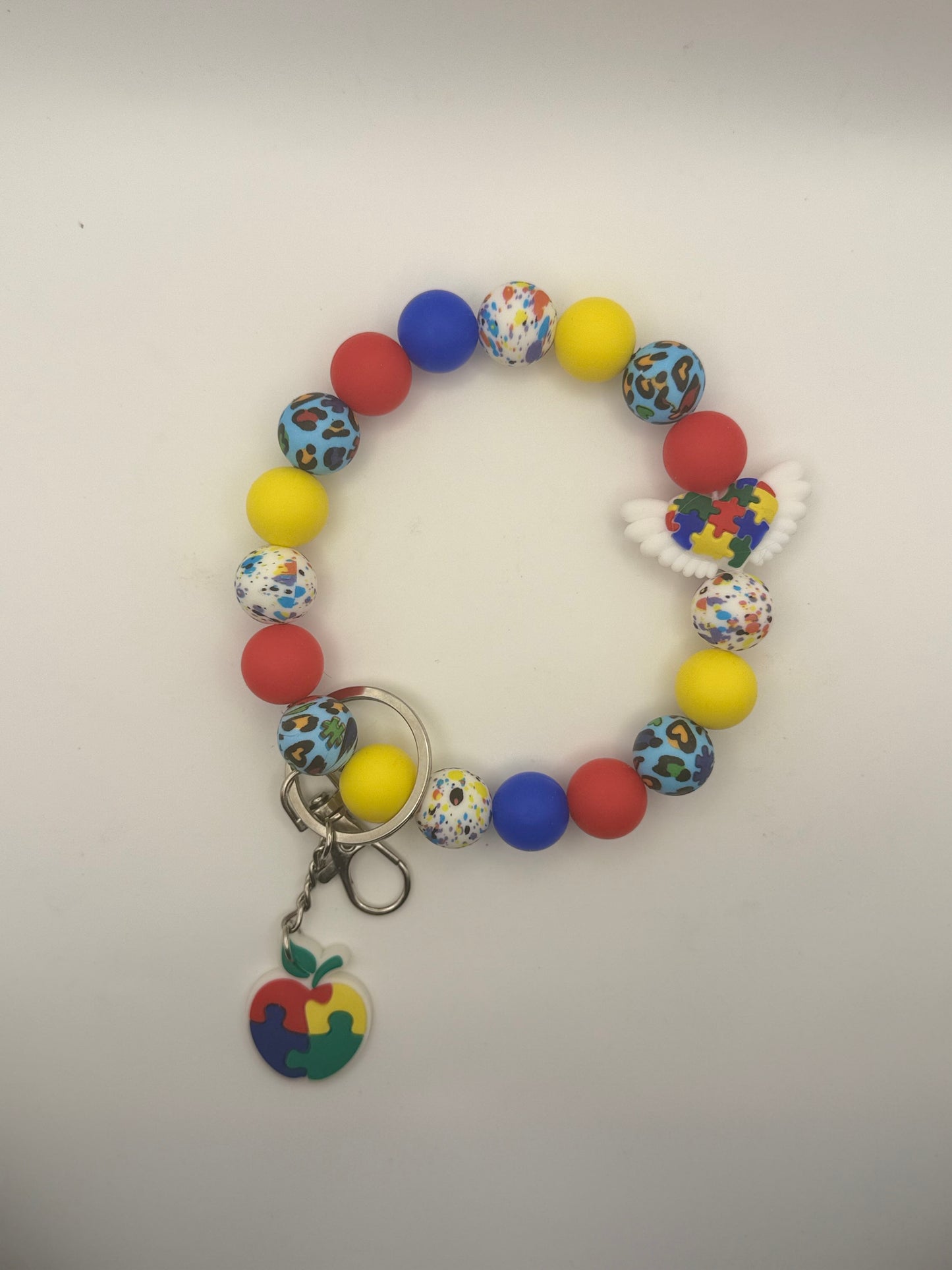 Colorful beaded bracelet with a keychain on a light gray background